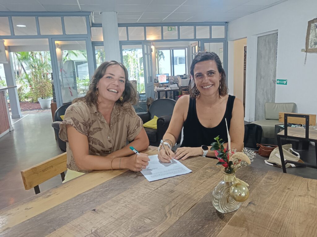 Image des deux professionnelles du dispositif Loisir’Handicap 974 qui sont assises à une table, en train de signer un document, illustrant le travail de coordination et de mise en place du dispositif.